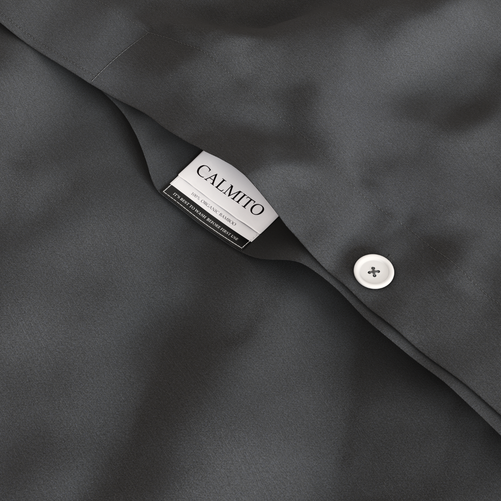 Close-up of a dark gray fabric with a Calmito label and button.
