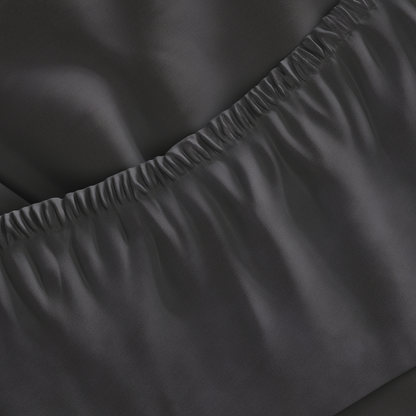 Close-up of dark gray fitted sheet with a slight wrinkle on a surface.